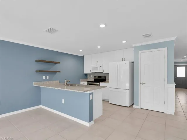 Dining Area and Kitchen With White Shaker Cabinets, Island, Granite Countertops, Added Backsplash, Pantry, New White GE Dishwasher, Microwave, and Refrigerator With Icemaker, and Stainless Steel Frigidaire Range With Self-Cleaning Oven