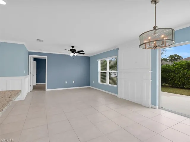 Great Room and Dining Area With Crown Molding, Tile Flooring, Custom Woodwork Wall Featurre, and Faux Wood Blinds