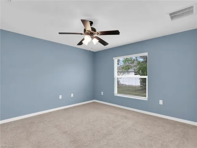 Primary Bedroom With Ceiling Fan And Faux Wood Blinds
