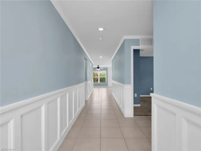 Foyer and Entry Hallway With Crown Molding and Wainscotting