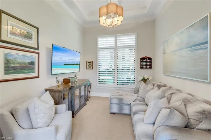 Den or Office Area crown molding, a chandelier, carpet floors, and a raised ceiling