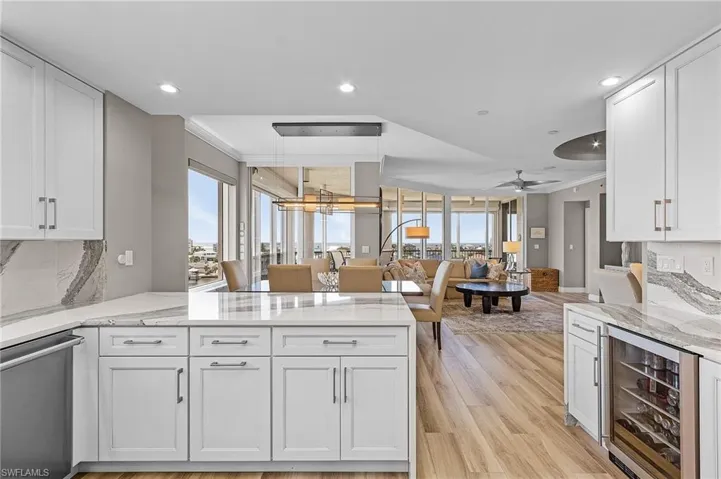 Kitchen featuring white cabinetry, dishwasher, ceiling fan, and beverage cooler