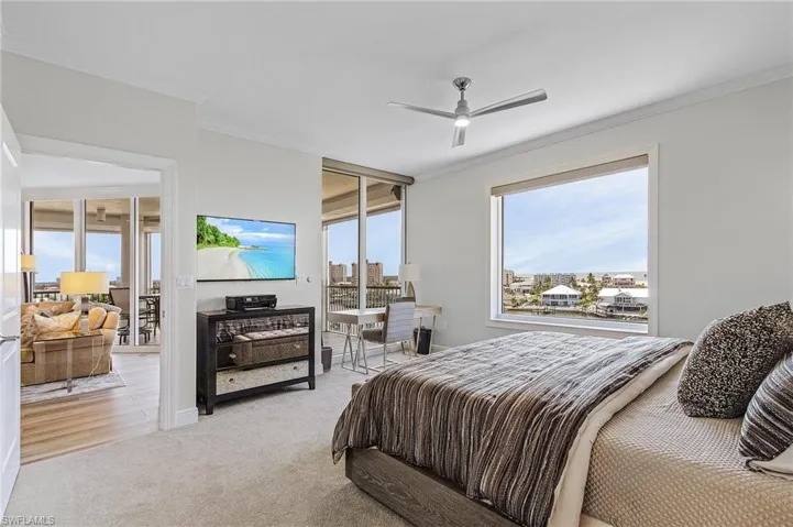 Bedroom with crown molding, light carpet, and ceiling fan