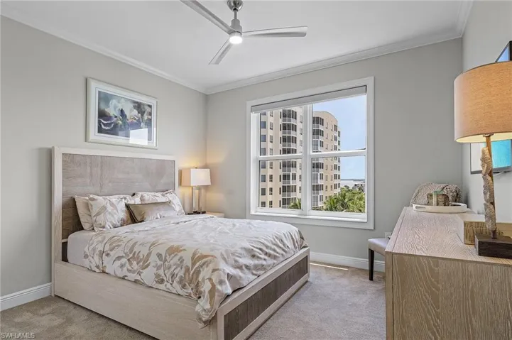 Carpeted bedroom featuring ornamental molding and ceiling fan