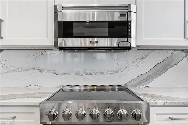 Room details featuring white cabinets and light stone counters