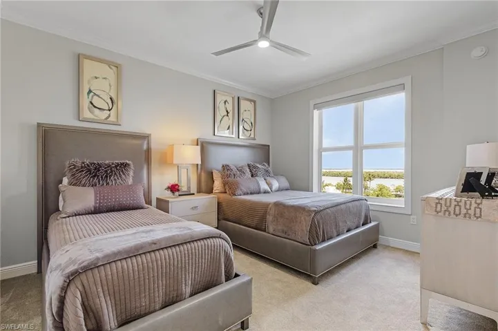 Bedroom featuring light carpet, crown molding, and ceiling fan