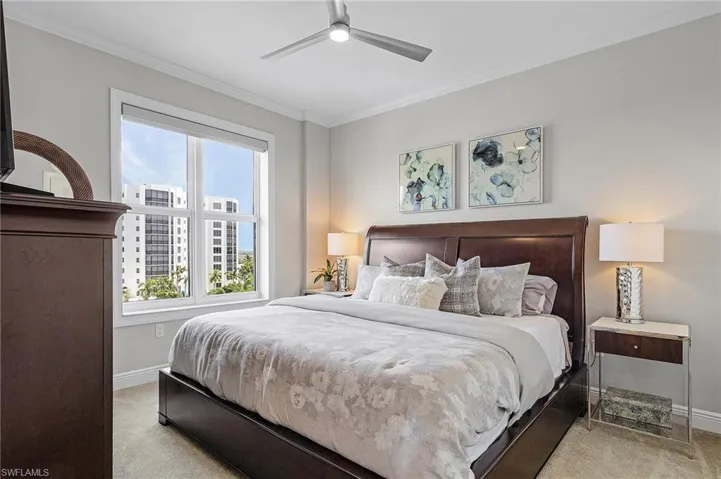 Carpeted bedroom with crown molding and ceiling fan