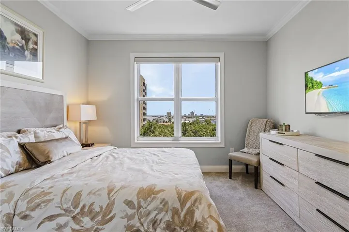 Carpeted bedroom featuring ornamental molding and ceiling fan
