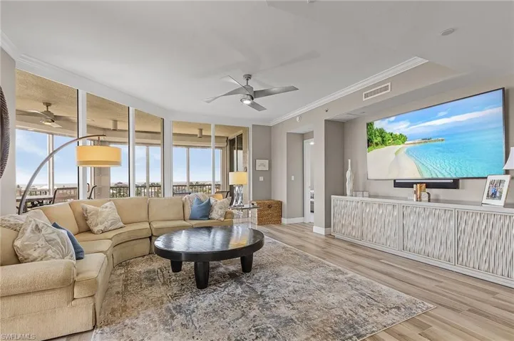 Living room with crown molding, light hardwood / wood-style flooring, and ceiling fan