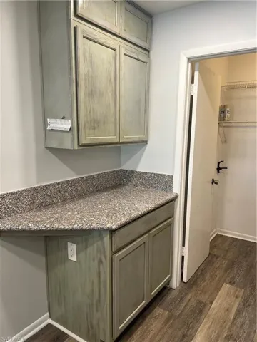Bathroom with dark wood finished floors, vanity, and a spacious closet