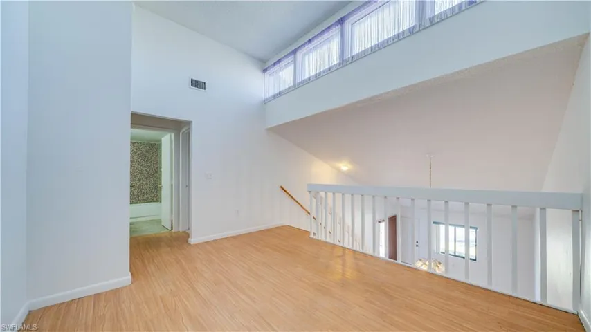 Empty room with a high ceiling and light wood-type flooring