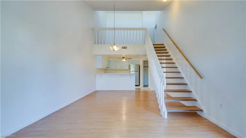 Staircase featuring wood finished floors and a high ceiling