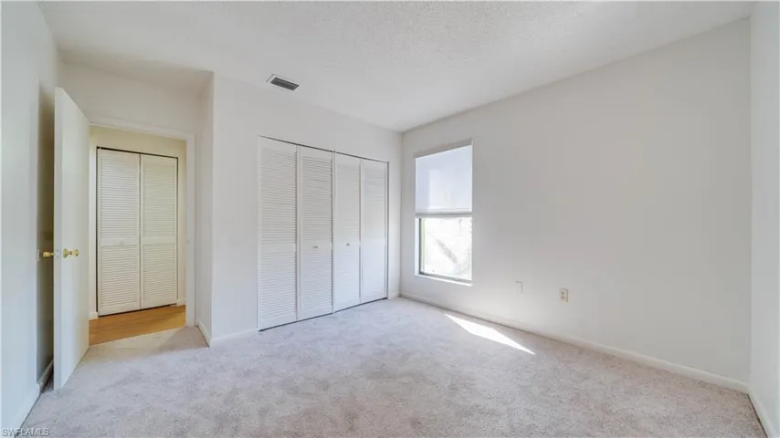 Unfurnished bedroom with a textured ceiling, carpet, and a closet
