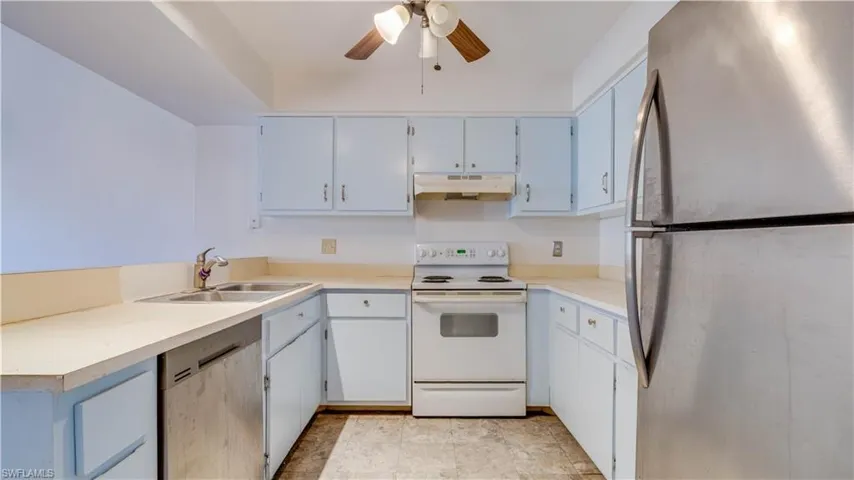 Kitchen featuring stainless steel appliances, ceiling fan, and light countertops