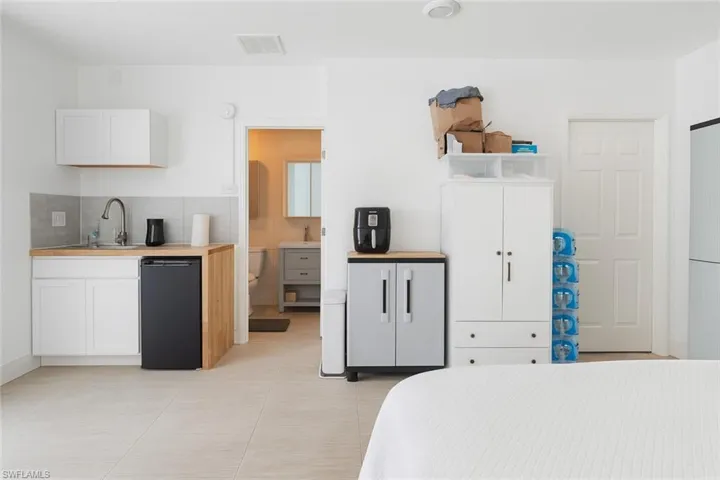 Bedroom featuring light tile patterned floors and ensuite bathroom