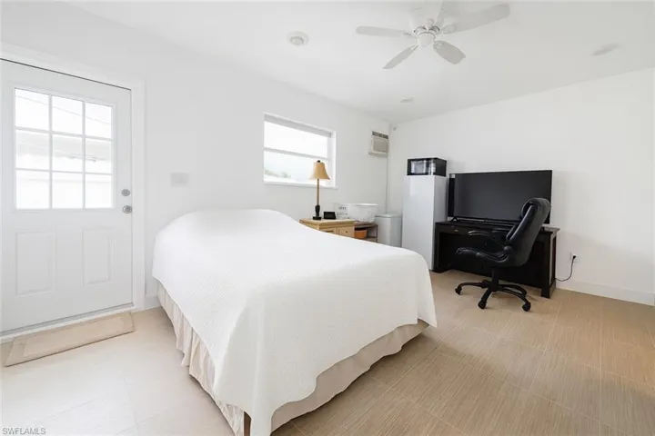 Bedroom with ceiling fan and a wall mounted air conditioner