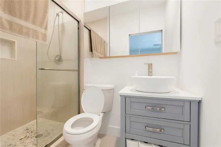 Full bathroom with vanity and a shower stall
