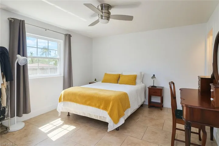 Bedroom featuring light tile patterned floors and ceiling fan