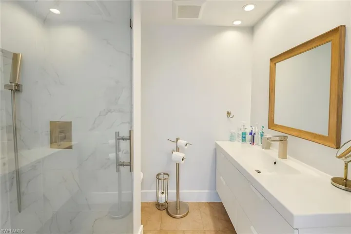 Bathroom with vanity, a marble finish shower, recessed lighting, and tile patterned floors