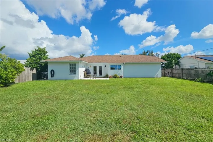 Back of property with french doors, stucco siding, a fenced backyard, and a patio