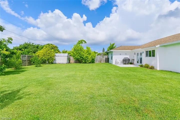 Fenced backyard featuring french doors and a storage shed