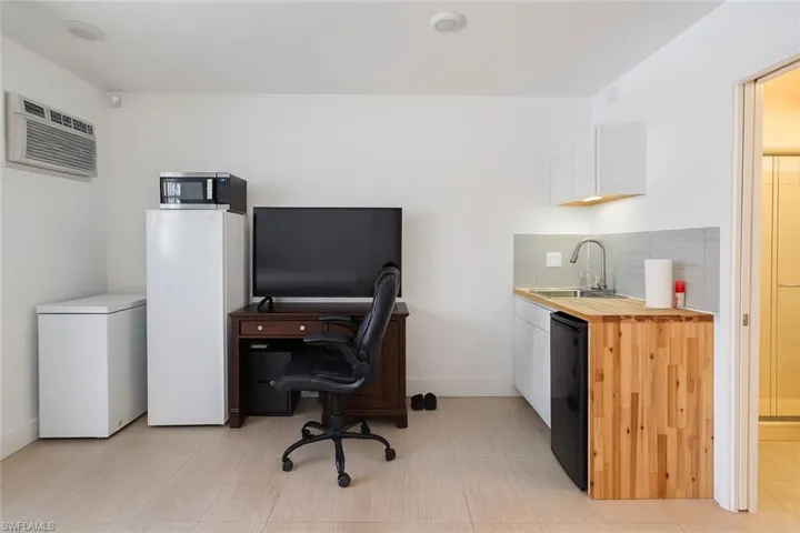 Office area featuring a wall mounted air conditioner and a sink