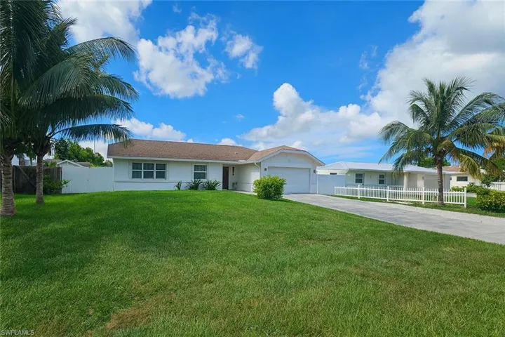 Ranch-style home featuring concrete driveway, an attached garage, and stucco siding