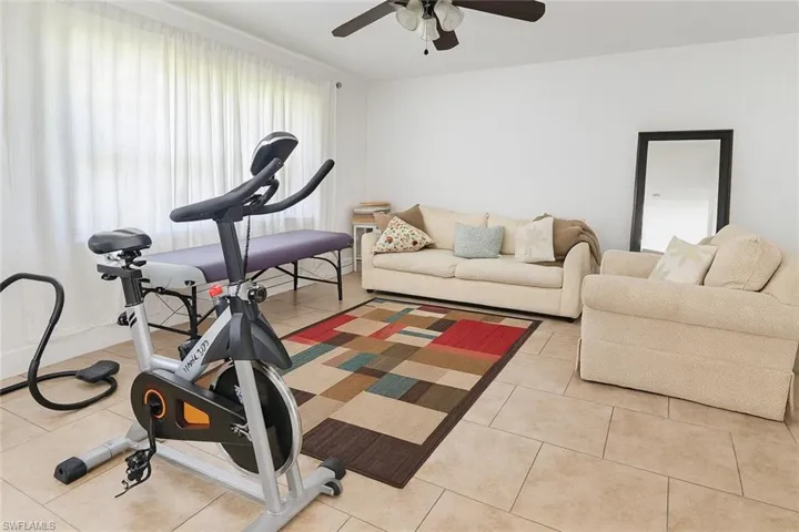 Exercise area featuring tile patterned floors and a ceiling fan