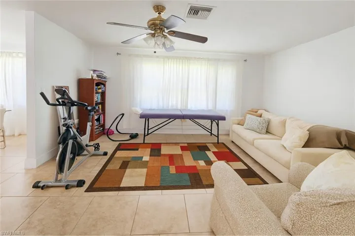Living room with tile patterned floors and a ceiling fan