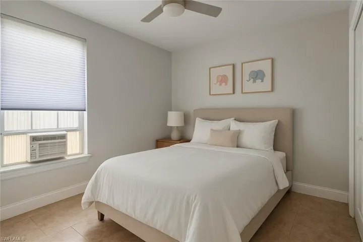 Bedroom with tile patterned floors and a ceiling fan