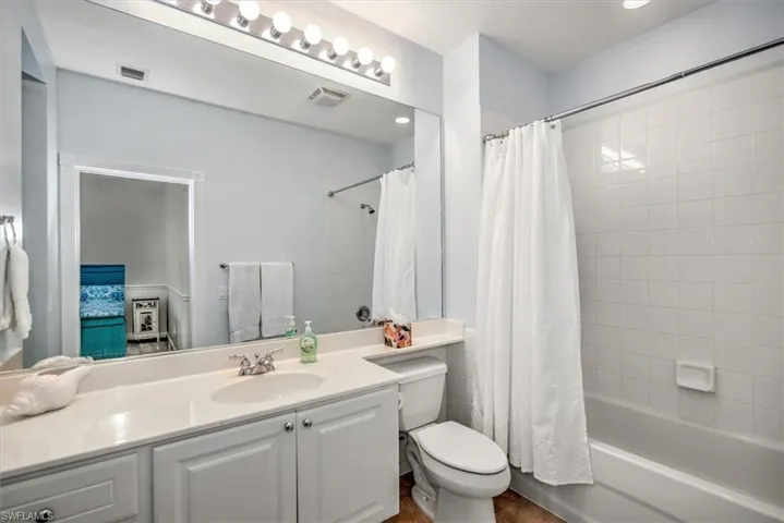 Hall BA Vanity with white cabinetry, integrated sink, and light-colored countertop