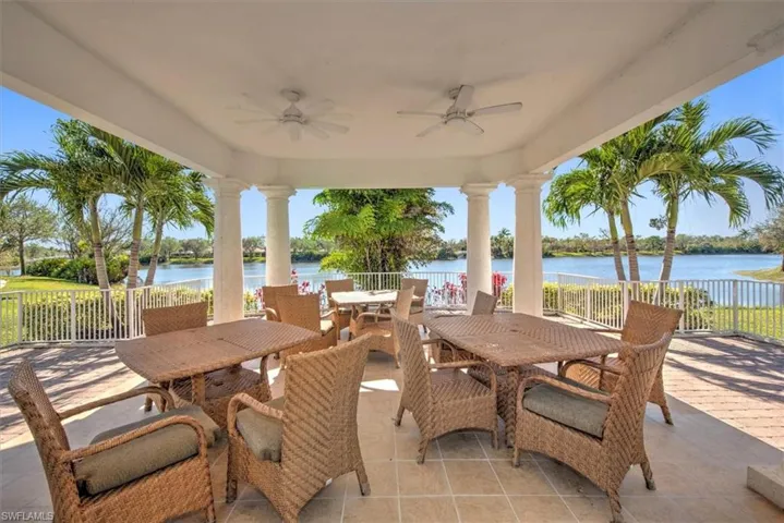 Covered patio featuring classical columns, two ceiling fans, and a tiled floor