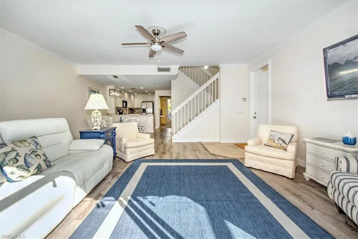 Bright living area featuring wood-finish waterproof vynil flooring, a ceiling fan, slider taking you to you private courtyard style screened lanai .
