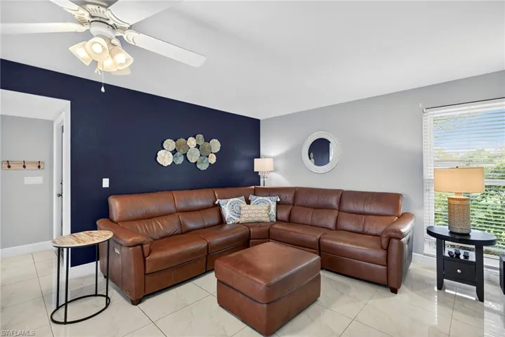 Living area with a ceiling fan and marble look tiles