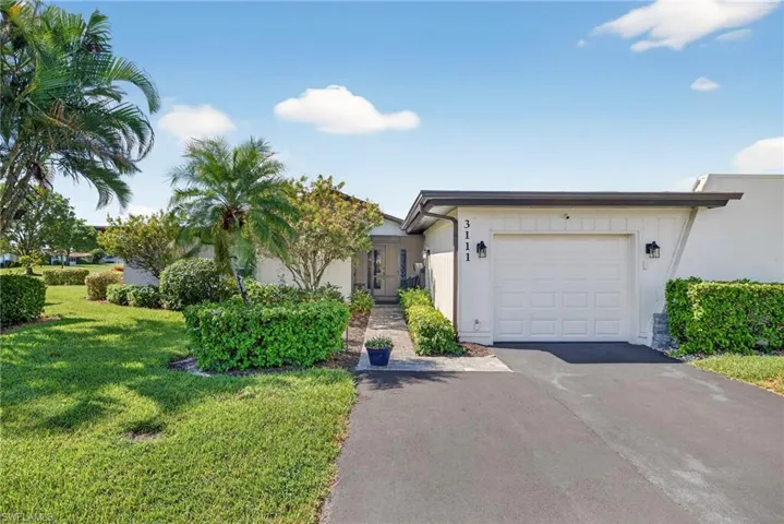 Single story home with asphalt driveway, a front lawn, and a garage