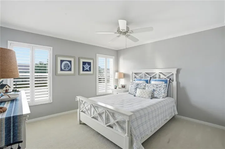 2nd Bedroom featuring multiple windows, crown molding, light carpet, and ceiling fan