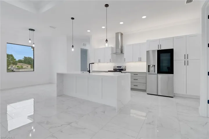 Kitchen with appliances with stainless steel finishes, wall chimney exhaust hood, recessed lighting, decorative backsplash, and a sink
