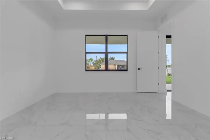Unfurnished room featuring baseboards and marble look tiles