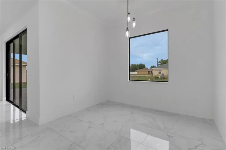 Empty room featuring baseboards, marble look tile flooring, and crown molding