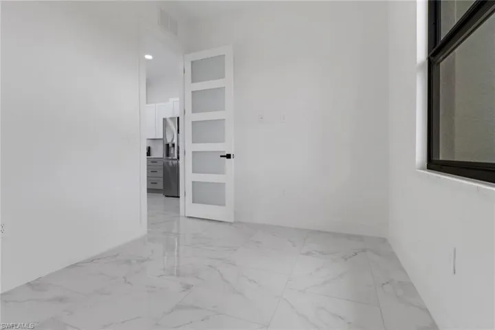 Empty room featuring light marble finish floors and baseboards