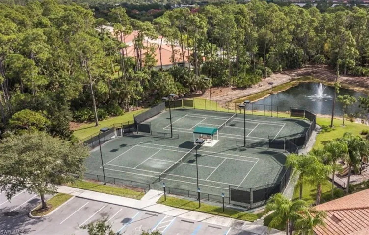View of tennis court with a water view