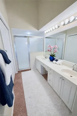 Bathroom with shower, double vanity and a walk in closet and linen closet