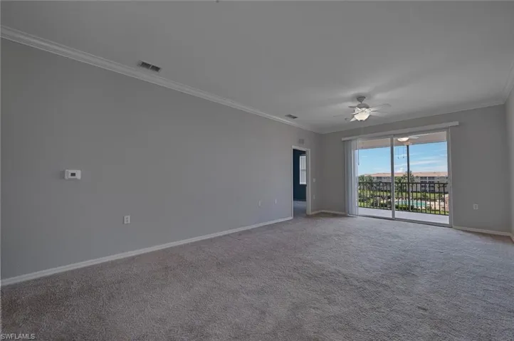 Unfurnished room featuring ornamental molding, carpet, and a ceiling fan