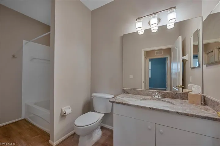 Full bathroom with shower / washtub combination, vanity, and light wood finished floors