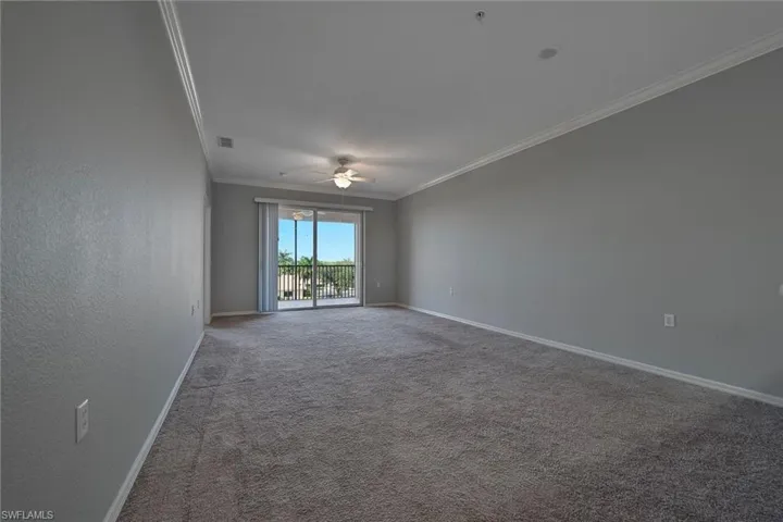 Spare room featuring crown molding, carpet flooring, a textured wall, and ceiling fan