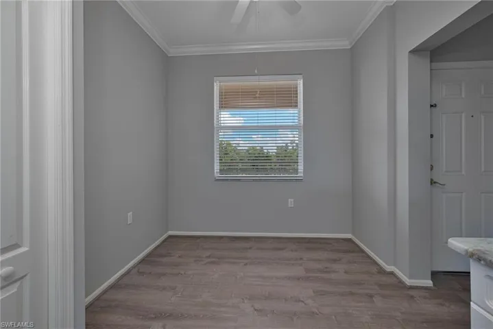 Unfurnished room featuring crown molding, light wood-style floors, and a ceiling fan