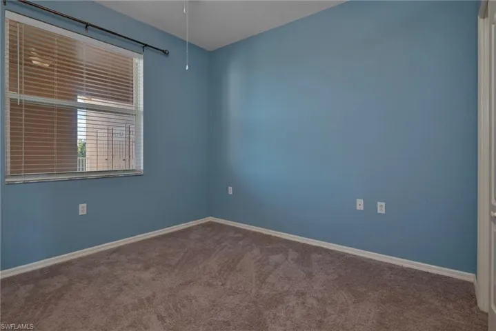 Carpeted empty room featuring baseboards