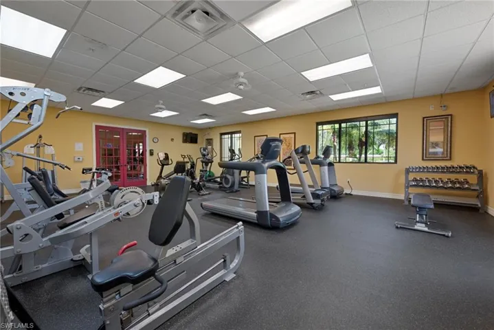 Workout area featuring a paneled ceiling and baseboards