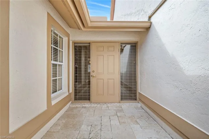 Doorway to property with stucco siding and a patio area