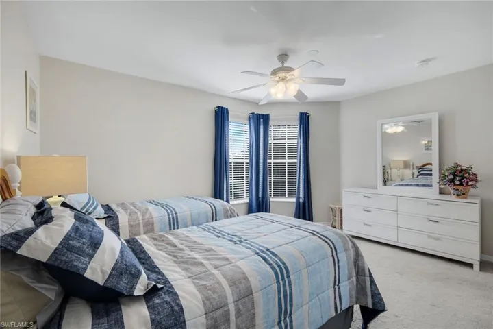 Bedroom featuring a ceiling fan and light colored carpet